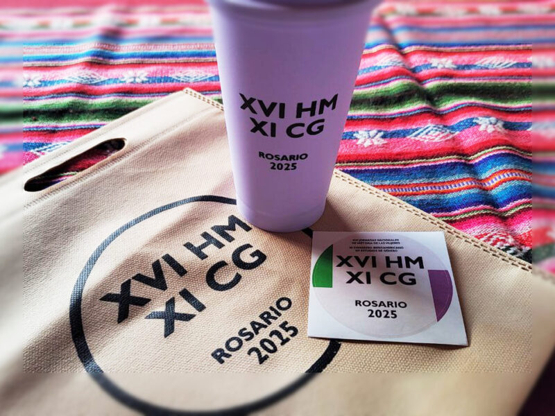 Vaso plástico, bolsa de tela y sticker, apoyados sobre una mesa. Los tres elementos tienen impreso el logo del evento.